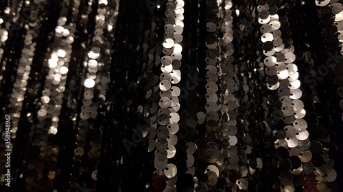 Glowing black silver sequins background with copy space