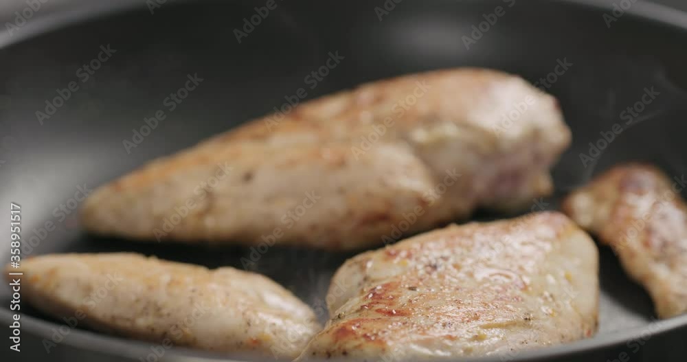 Slow motion chicken fillet frying on non stick pan closeup Slow motion chicken fillet frying on non stick pan closeup