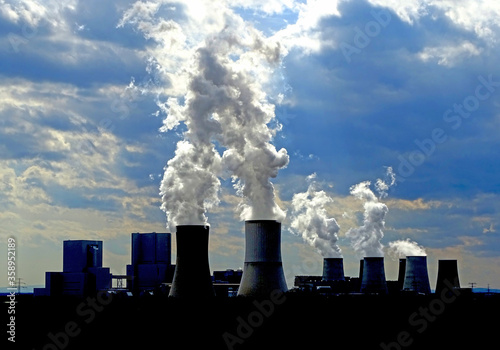 Smoking power plant with cloudy sky