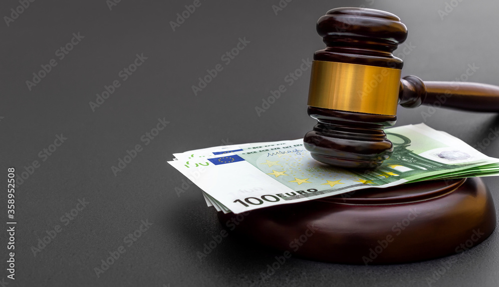 Judge's gavel with one hundred euro banknotes on black. Judge's gavel with one hundred euro banknotes on black.