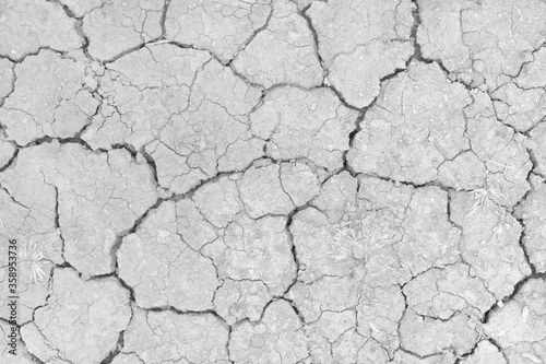Gray Dry soil surface with cracks under high solar activity and lack of moisture