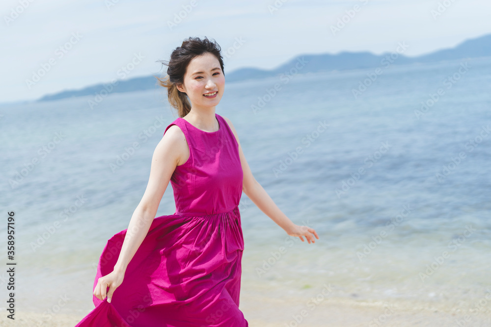 リゾートで海沿いを歩く女性