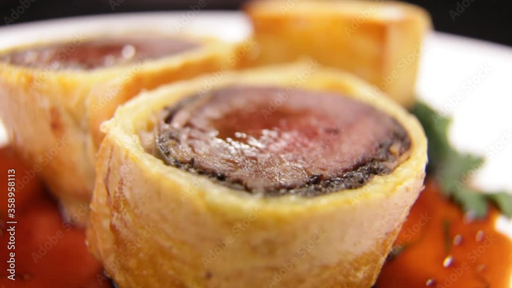 Very close-up of Slice of Beef Wellington with Spinach and fried potatoes. Very close-up of Slice of Beef Wellington with Spinach and fried potatoes.