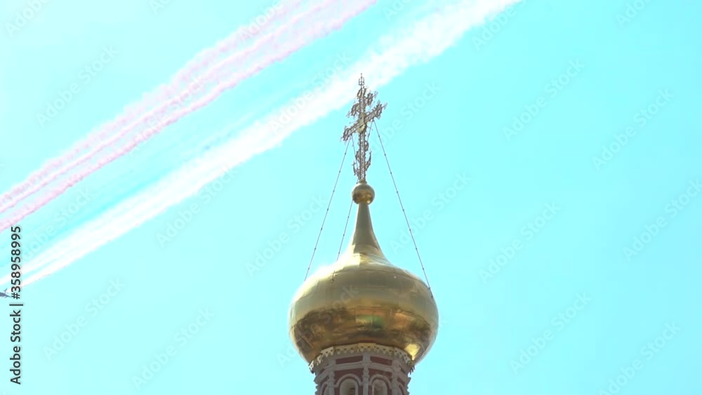 Fighter aircraft reserve the flag of Russia in three colors. A military plane flies over the dome of the church with a closeup of the cross, teaching Russian aviation, Moscow.
Fighter aircraft reserve the flag of Russia in three colors. A military plane flies over the dome of the church with a closeup of the cross, teaching Russian aviation, Moscow.