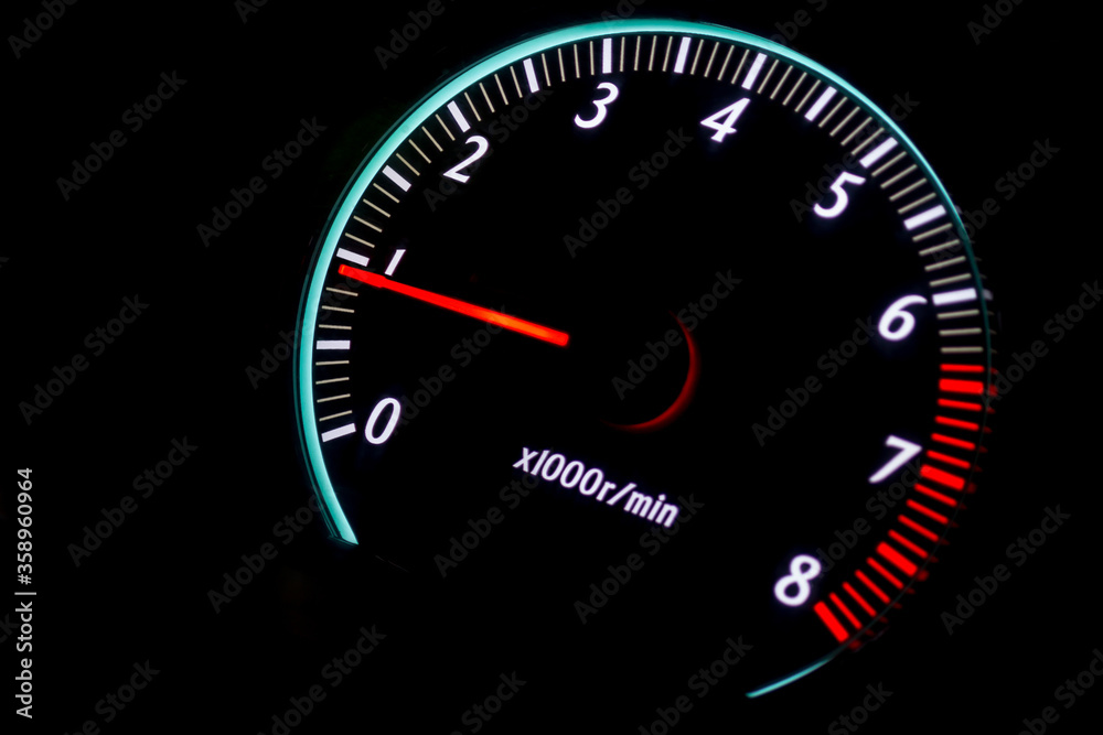 car tachometer with red arrow on black background
