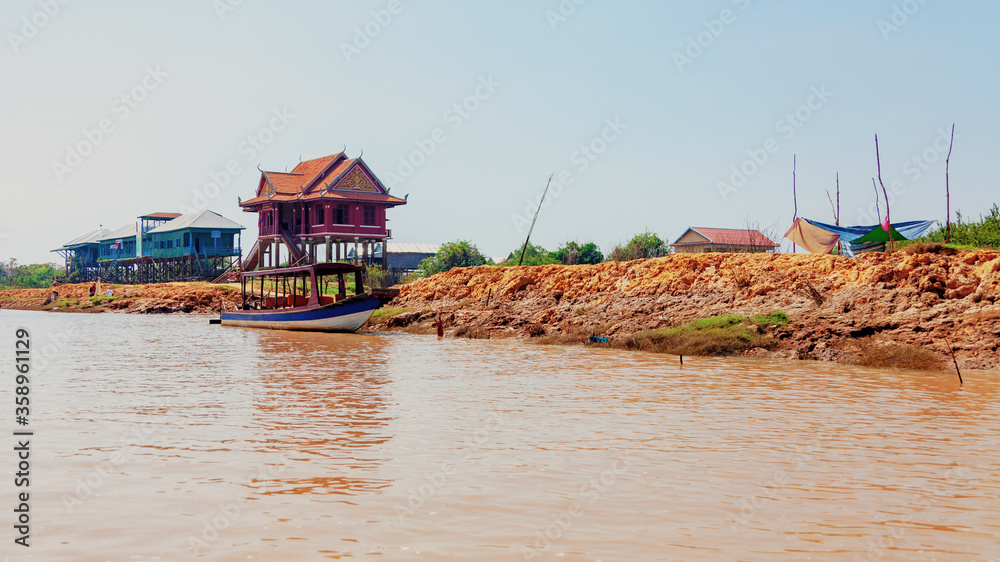 Tonle Sap lake. Kampong Phluk floating fishing village during drought season. Houses on stilts, people and boats. Poor country. Life and work residents Cambodian on water, near Siem Reap, Cambodia