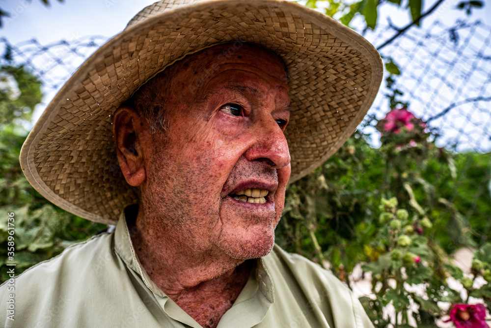 Face portrait of senior man with straw hat