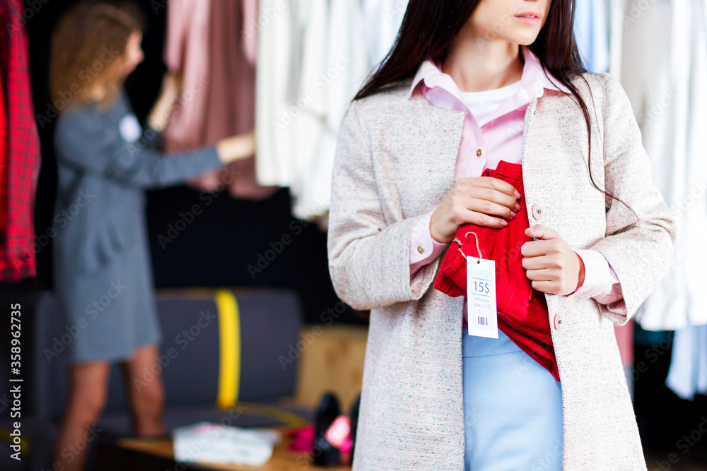 Closeup Of Young Woman Is Stealing Red Jeans In Store Shop Boutique At Shopping Center Girl