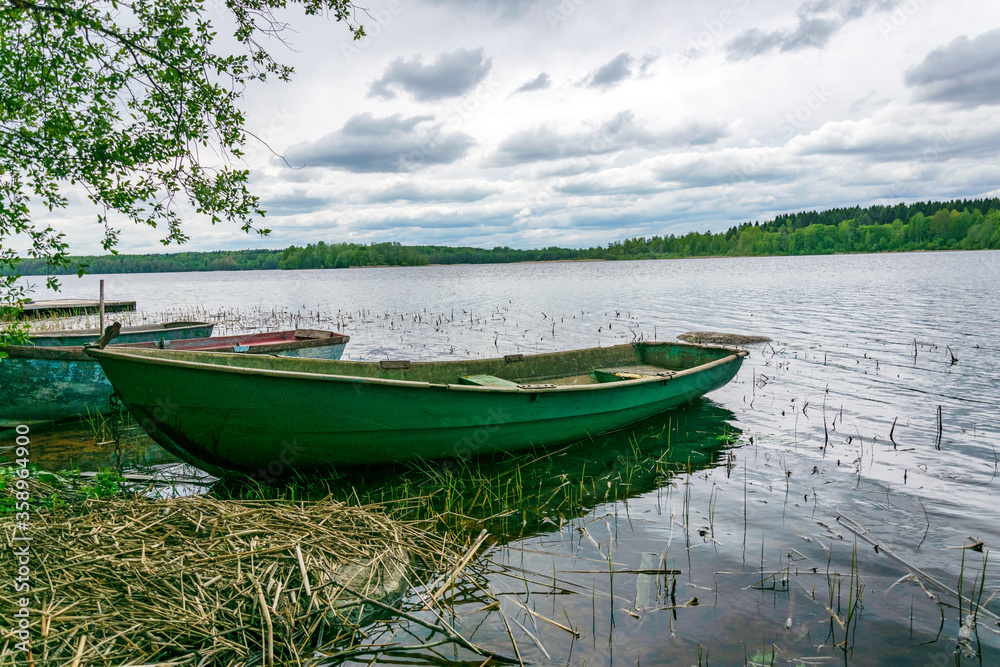 Fototapeta Boats on the shore of a picturesque lake.