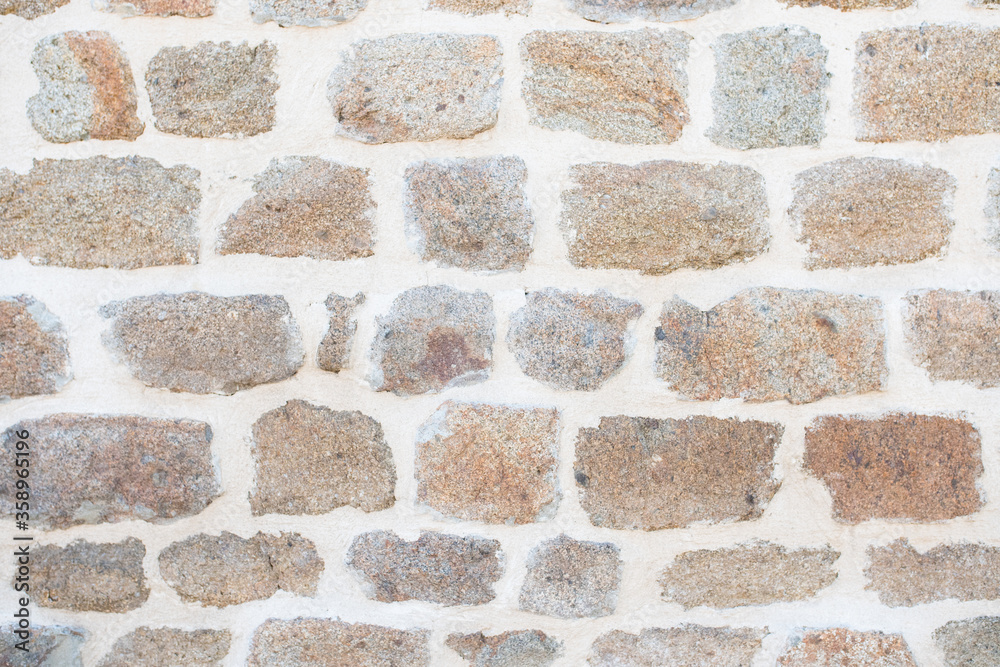 Obraz premium Background or Texture of a Stone Wall from a Traditional Country Cottage in England (UK) or Normandy (France).