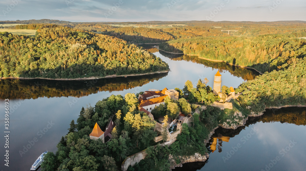 Aerial beautiful view of Zvikov Castle, Czech Republic.Picturesque landscape with castle, trees and water.Spring scenery by sunset.Gothic castle standing on a rock above the river