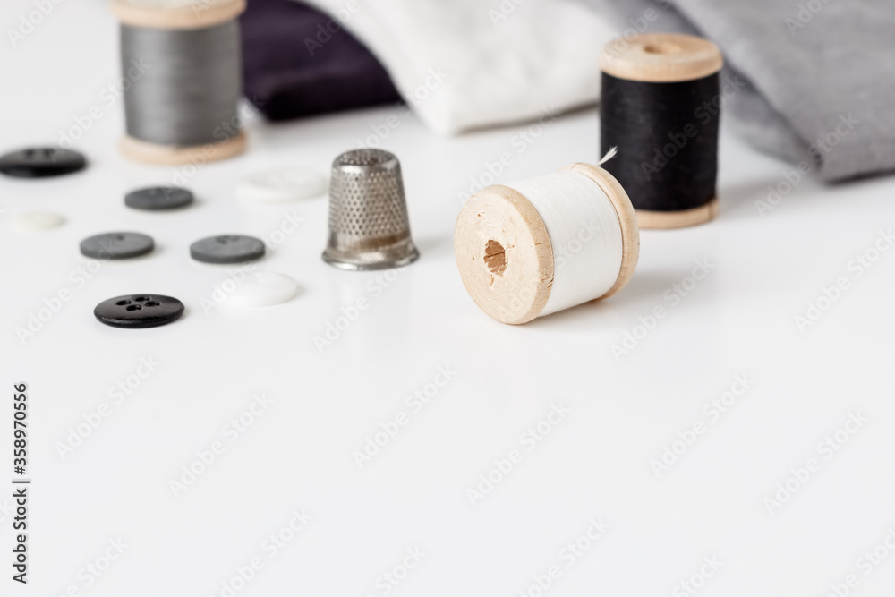 Linen textiles, scissors and sewing supplies on white desk Linen textiles, scissors and sewing supplies on white desk