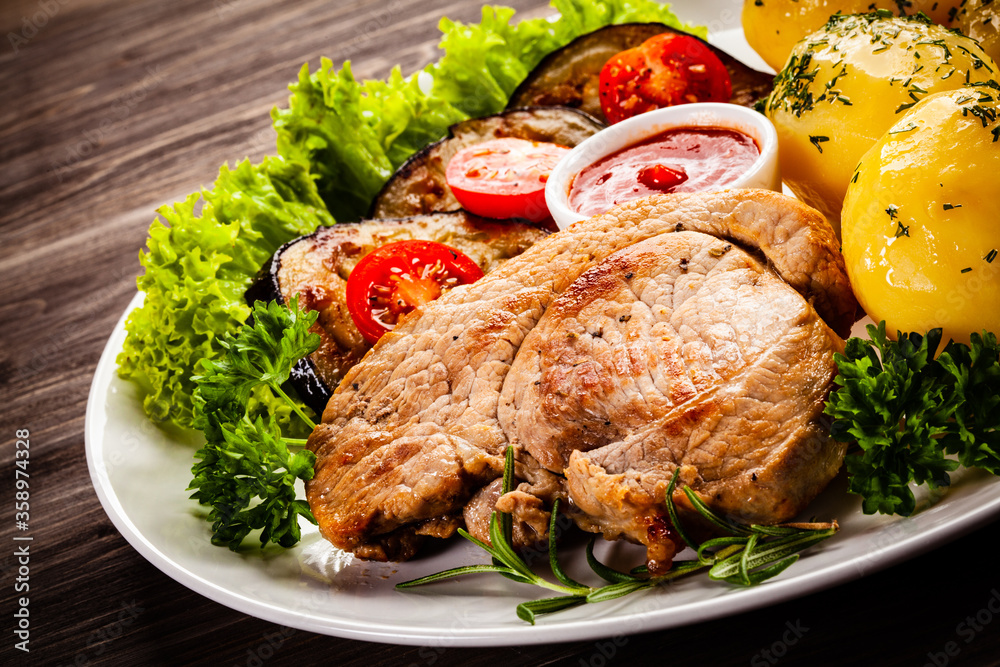 Barbecue beef steak fried potatoes and vegetables on wooden table
Barbecue beef steak fried potatoes and vegetables on wooden table