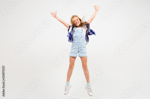 portrait of happy european girl waving hands on white wall