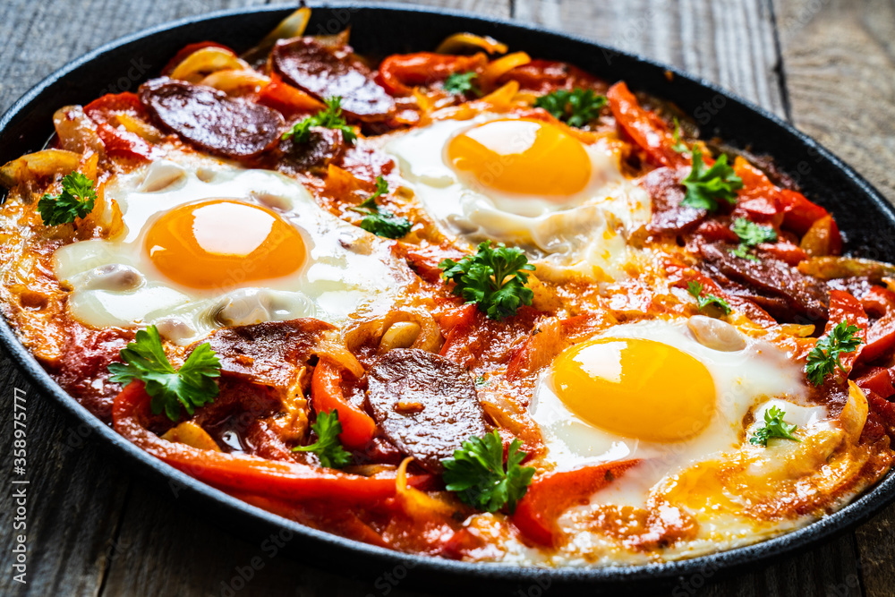 Shakshuka - fried eggs with chorizo and vegetables in frying pan
Shakshuka - fried eggs with chorizo and vegetables in frying pan