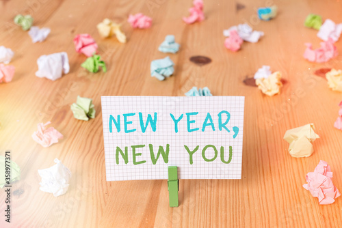 Conceptual hand writing showing New Year, New You. Concept meaning coming January Changing an individualality for a better an individual Colored crumpled papers wooden floor background clothespin photo