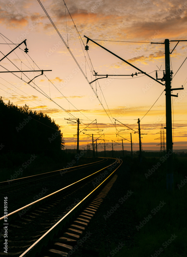 the rails shine from the rays of the setting sun