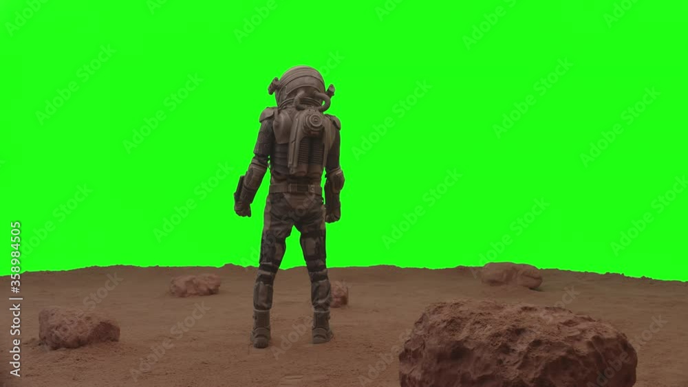 GREEN SCREEN CHROMA KEY Back view of astronaut walking on a surface of a red planet, cheking his HUD