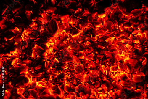 The bright wood embers of the fire glow with orange light. Texture