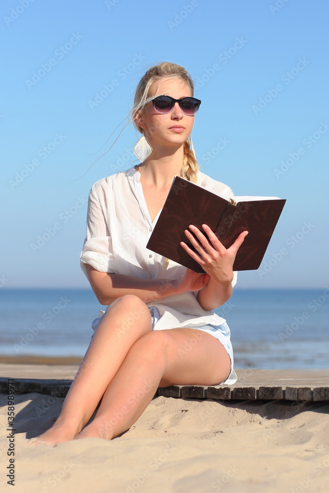 Woman reads a book on the beach