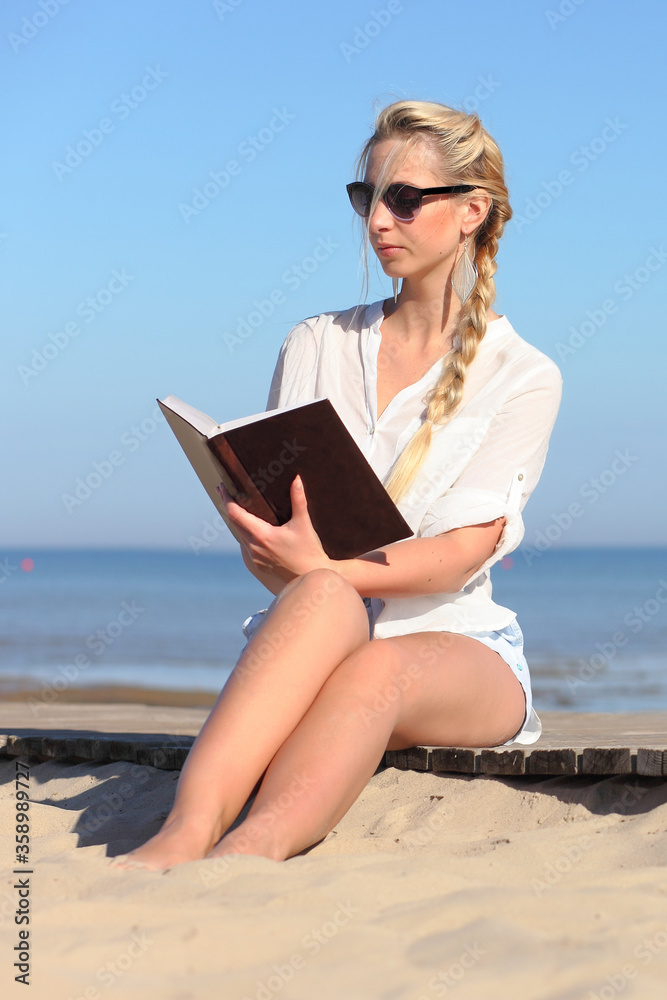 Woman reads a book on the beach
