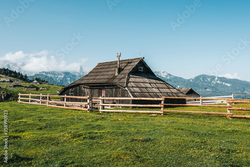 Mountain village surrounded by green meadows and Alps mountains. Traditional wooden shepherd houses on high plateau. Velika Planina or Big Pasture Plateau in Kamnik Alps, Slovenia.