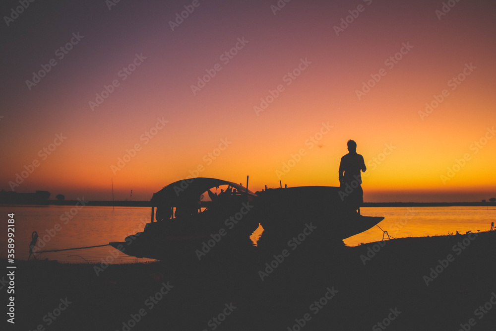 silhouette of a fisherman on the sunset