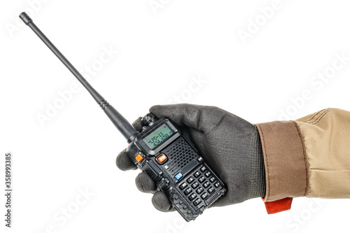 Worker hand in black protective glove and brown uniform holds modern walkie talkie isolated on white background