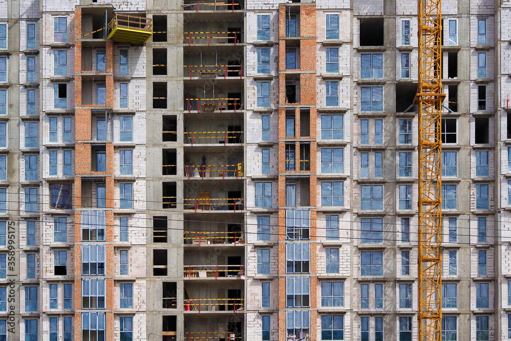 Fototapeta premium The construction of a residential building. Fragment of the facade of a house under construction. Construction fence
