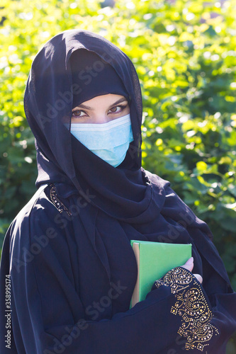 Oriental woman in a protective medical mask quaran in her hands.  photo