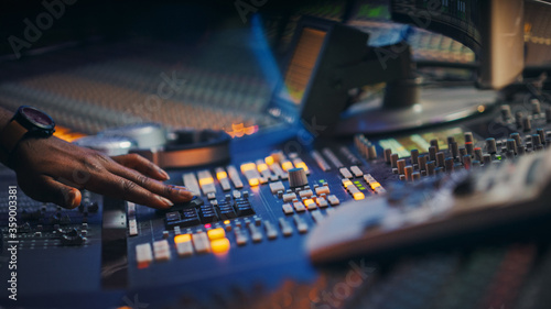 Close-up Shot of a Surface Control Desk Equalizer Mixer. Buttons, Faders, Sliders to Broadcast, Record, Play Hit Song. Artist Works in the Music Record Studio.