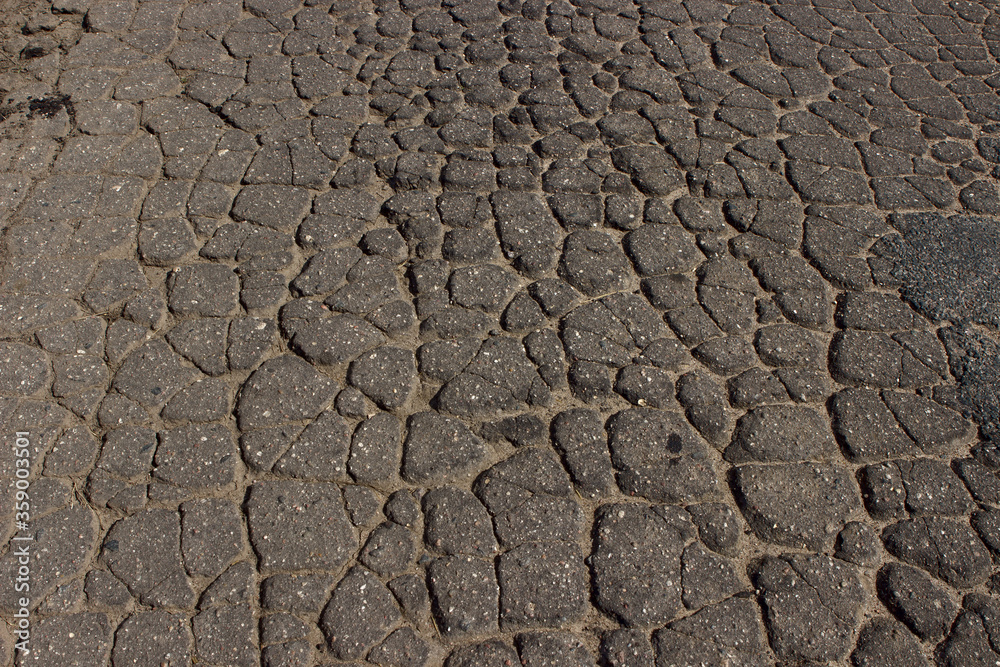 Cracked dry surface of an old gray asphalt road. Cracked dry surface of an old gray asphalt road.