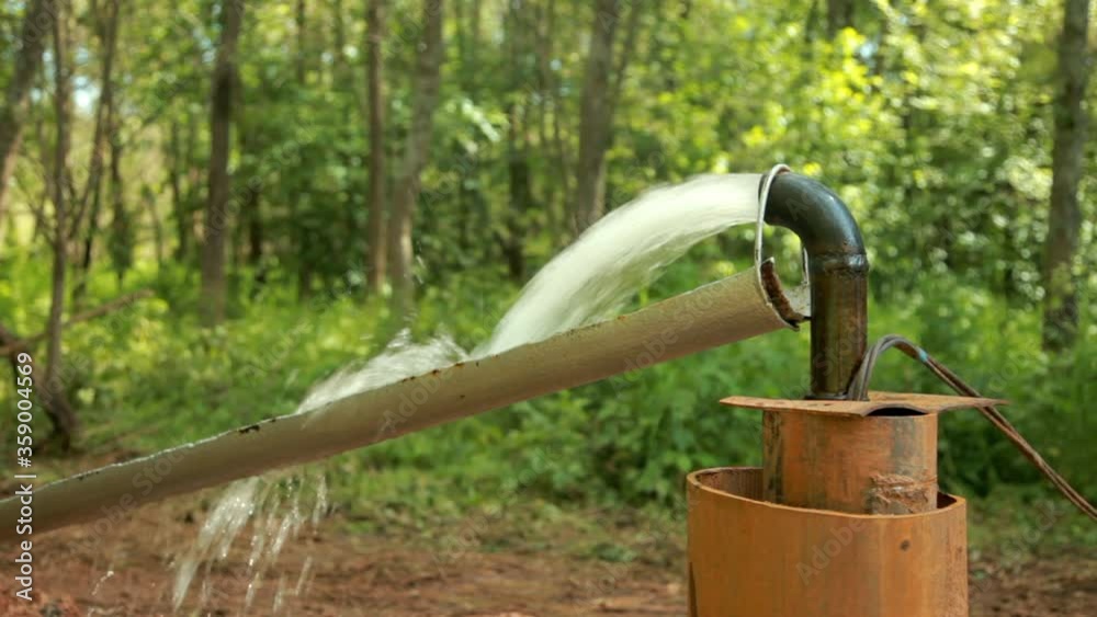 Powerful Water Flowing from a Pipe Pump.Water Pump.Water well drilling.Close-up. Powerful Water Flowing from a Pipe Pump.Water Pump.Water well drilling.Close-up.