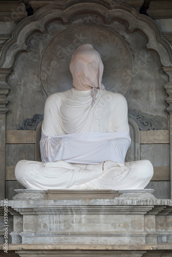 Statue of Buddha wrapped in white sheet in Buddhist temple under construction in Sri Lanka