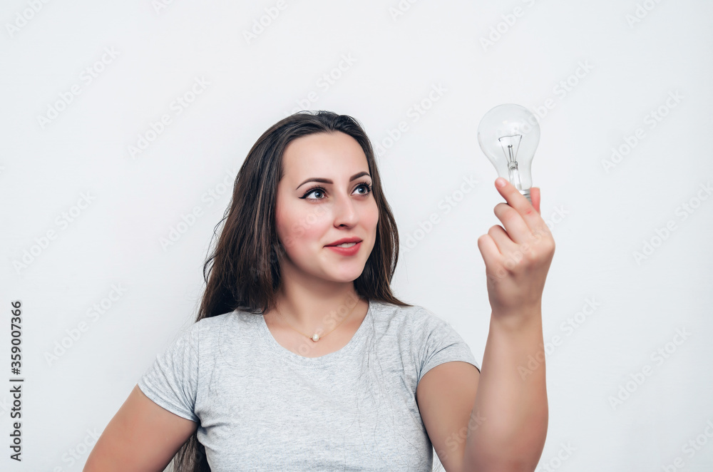 Girl holds a light bulb in hand. New idea, successful startup Girl holds a light bulb in hand. New idea, successful startup