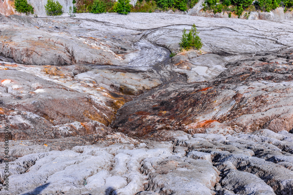 autumn landscape of the space valley with craters and rivers, against a blue sky with clouds and reflections
