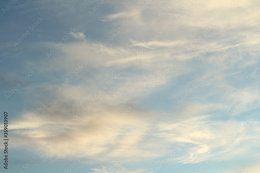 White fluffy clouds on a background of blue sky in summer. The concept of weather and climate.