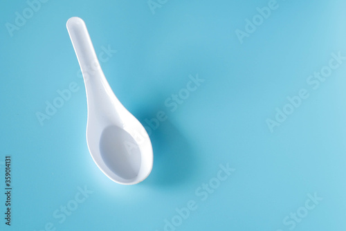 white plastic spoon on blue background