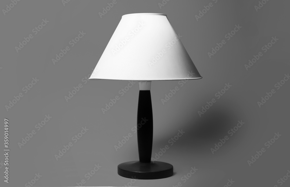 Minimal close-up portrait of room lamp in black and white on grey background. Minimal close-up portrait of room lamp in black and white on grey background.