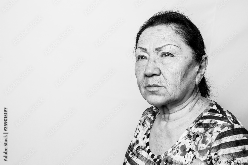 Fototapeta premium Portrait of elderly senior woman, back and white photo. Thinking about passed years. Loneliness, solitude. Black and white photo.
