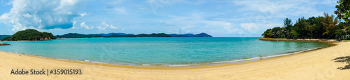 Panoramic shot of a beautiful golden sand beach with blue water beautiful fluffy clouds shot in Malaysia