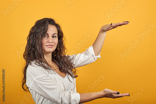 Shapes big object with two hands, gasps from surprise, holding palms in front and showing size something, holds empty open, indicate dimension while, demonstrating of item, for text design inside.