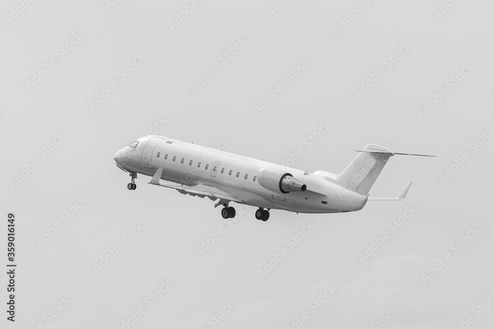 Obraz premium Flying airplane after taking off. White commercial passenger jet airliner in flight, no painting. Modern technology in fast transportation, business travel and tourism, aviation.