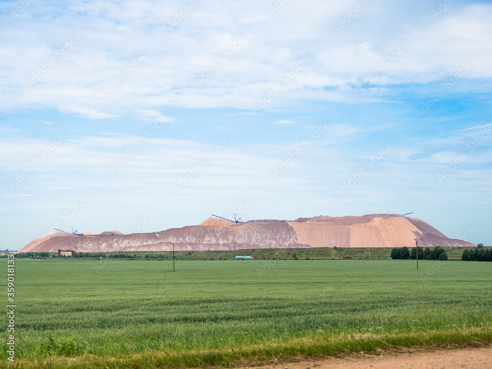 salt piles among the green fields. salt lake mining of potassium salts in Belarus. salt mining and production