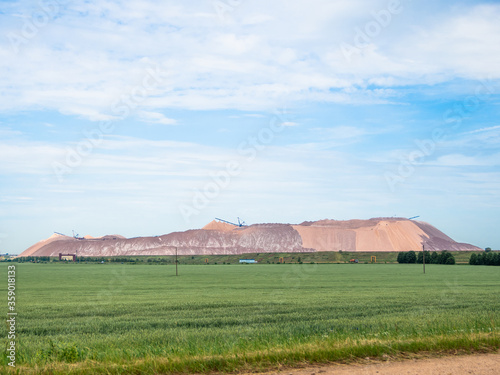 salt piles among the green fields. salt lake mining of potassium salts in Belarus. salt mining and production