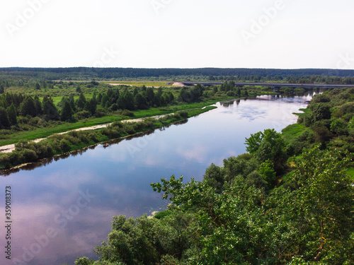 river with blue water surrounded by green trees. the view from the top. summer time