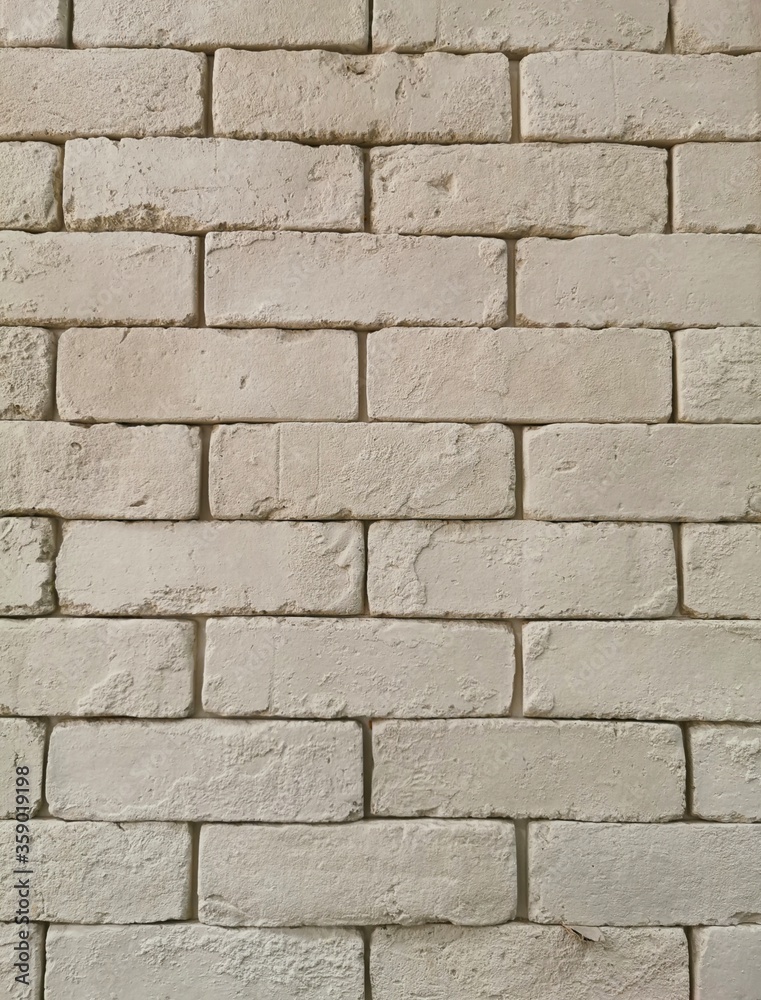 Fototapeta premium Beige brick wall background stock photo. Beige stone wall image.