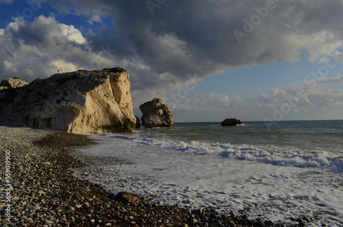 Paphos. Cyprus. Petra tou romiou. Aphrodite's rock. View from the postcard dramatic stormy sky over the sea. Rocks in the sea. The birthplace of the goddess Aphrodite. Romantic beach for lovers. 