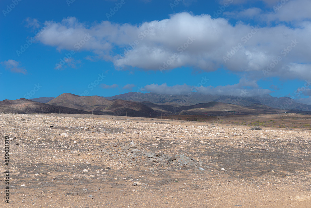 desert landscape of the canary islands with beautiful mountains and a rather attractive sky with some clouds desert landscape of the canary islands with beautiful mountains and a rather attractive sky with some clouds