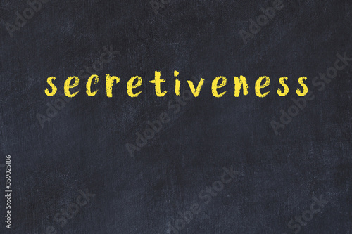 College chalk desk with the word secretiveness written on in